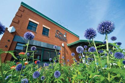 Red brick co-op building with flowes in the foreground